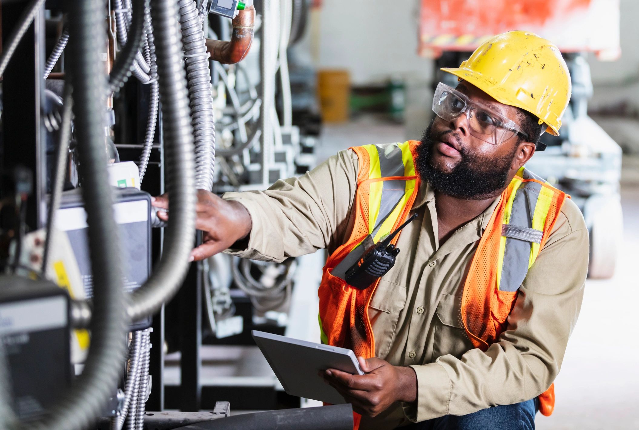 Engineer inspecting mechanical equipment in a plant room
