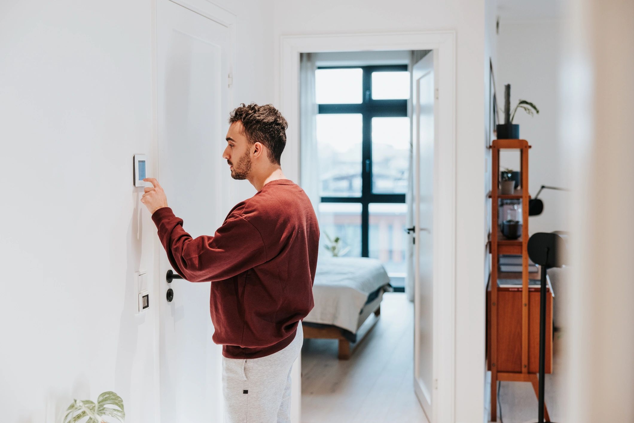 Homeowner adjusting a smart thermostat